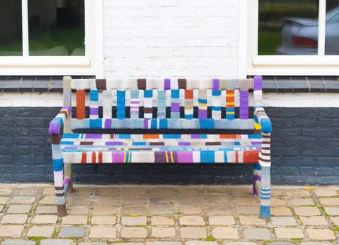 colorful decorated outdoor bench in front of a house