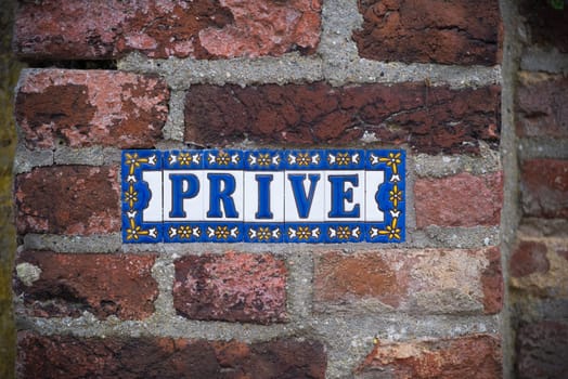 Prive (private in english) sign on a stone brick wall