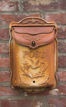 old rusty mailbox on a red brick wall