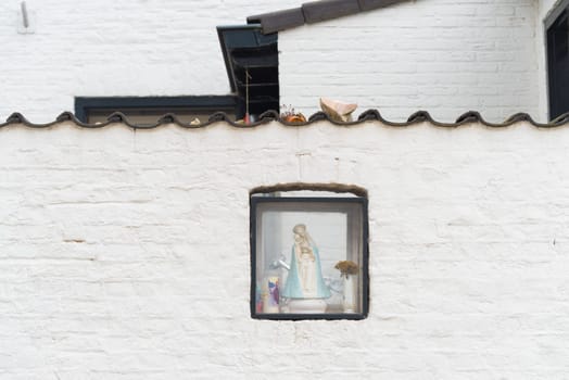 small box with virgin mary in a white brick wall