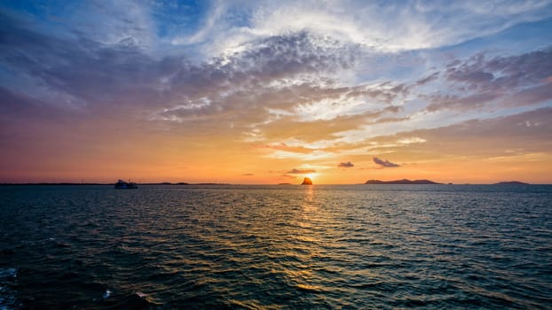 Beautiful natural landscape of colorful cloud sky and sun at sunset over the sea in Surat Thani province, Thailand, 16:9 widescreen