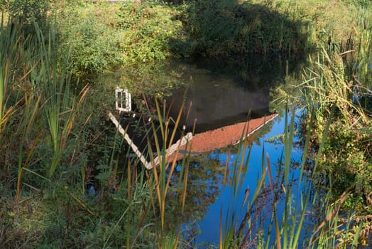 small wooden barn reflected in a pond