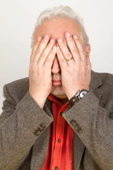 Senior holds his hands in front of his face