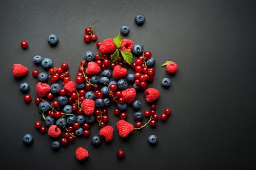 Bowl of fresh mixed berries on black background