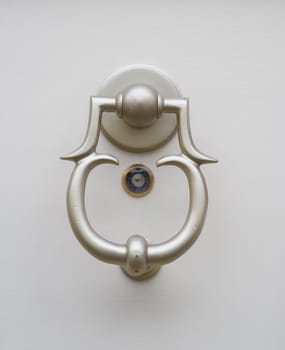 closeup of a metal doorknob with a small peephole under it