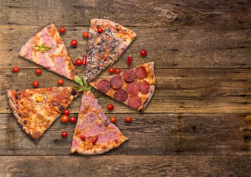 Italian food - pizza on wooden table. Cherry tomato and hot peppers around