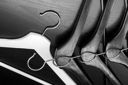 White hanger and a few black hangers, black background, abstract