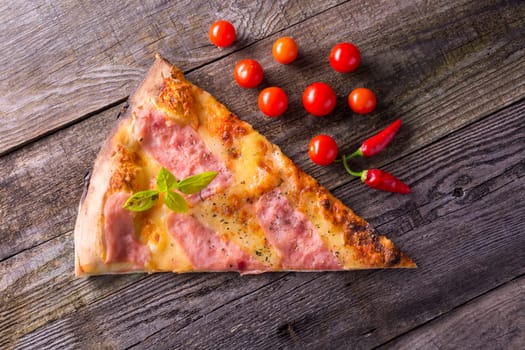 Italian food - pizza on wooden table. Cherry tomato and hot peppers