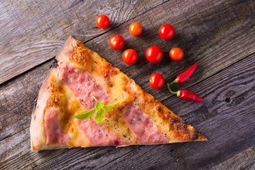 Italian food - pizza on wooden table. Cherry tomato and hot peppers