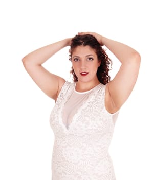 A portrait of a serious woman in a beige dress and curly brunette.hair standing from front, isolated for white background.