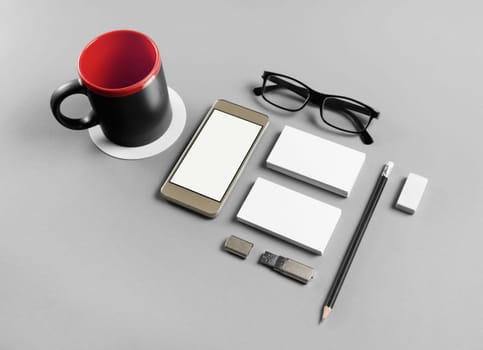 Photo of blank stationery and smartphone set on gray paper background. Branding template. Objects for placing your design.