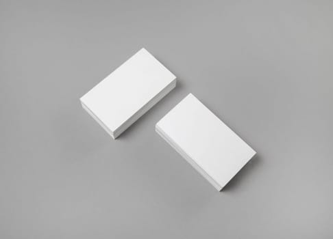 Photo of blank business cards on gray paper background. Template for ID. Mock-up for branding identity. Top view.
