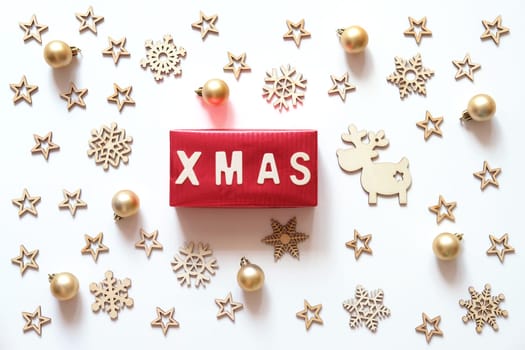 Christmas holidays minimal background.  Xmas word made of wooden letters on red gift box with Christmas decoration on white background.