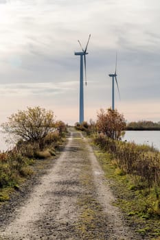 Wind Power Stations by Gravel Road and Ocean.