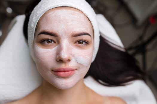 Close-up shot of a woman getting facial treatment with clay mask. Cosmetology and spa. High quality 4k footage