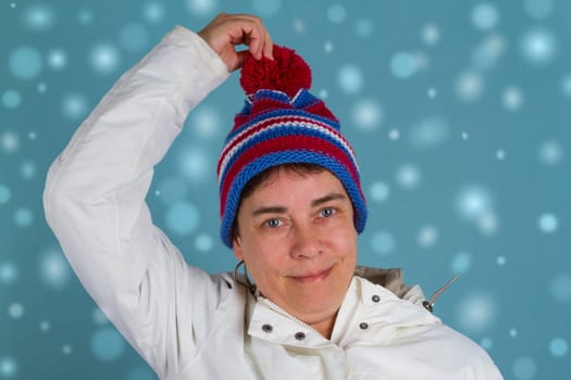Middle-aged woman in winter clothes on a blue background
