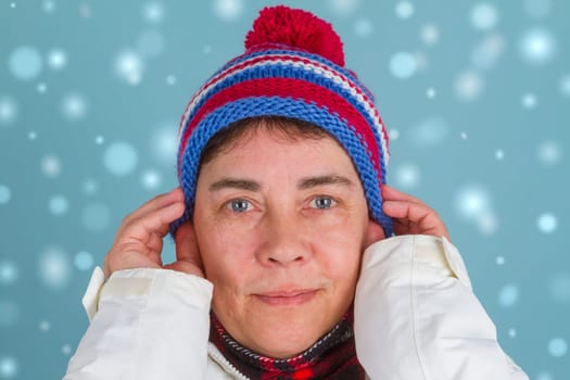 Woman sits down poodle muffles with snowflakes in the background
