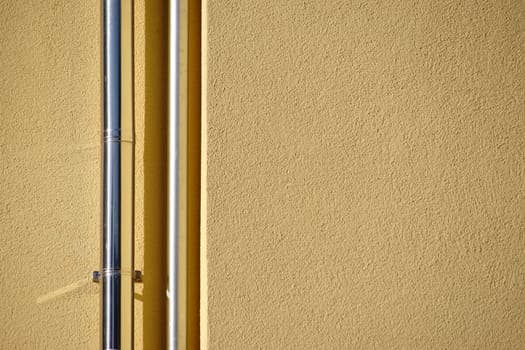 The close-up of newly laid stainless steel rain pipes on a new façade.