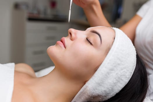 Close-up shot of a woman getting facial treatment with clay mask. Cosmetology and spa. High quality 4k footage