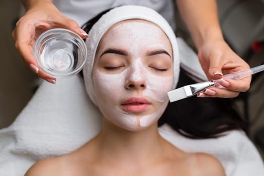 Close-up shot of a woman getting facial treatment with clay mask. Cosmetology and spa. High quality 4k footage