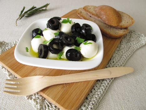 Marinated mozzarella with black olives,olive oil and leaf mustard