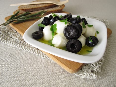 Marinated mozzarella with black olives,olive oil and leaf mustard