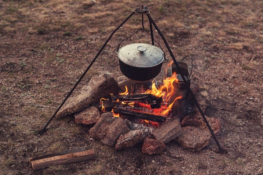 Preparing food on campfire in wild camping, resting on the nature