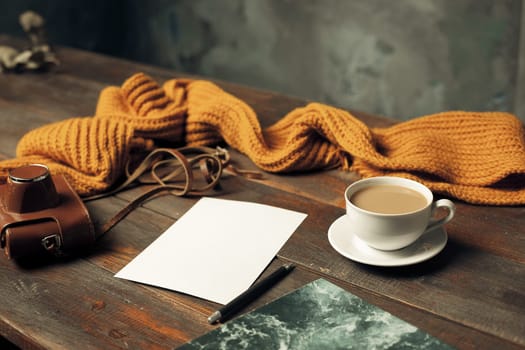 Opened craft paper envelope , autumn leaves and coffee on rustic wooden table