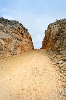 Dirt road dug in the hill in the mountains on the island of Crete