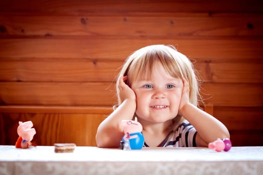 little girl with her toys on the table