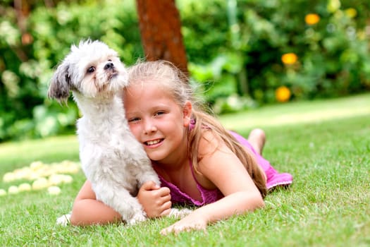 cute young girl with her dog in the garden