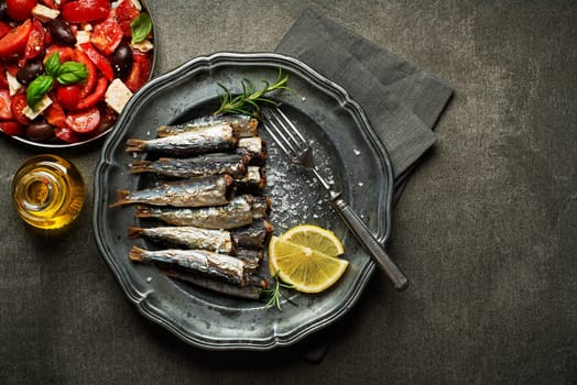 Fried sardines with salt and herbs on rustic background