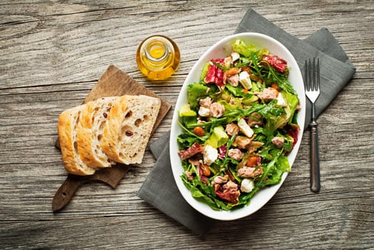 Tuna salad with lettuce, beans and cheese on wooden table