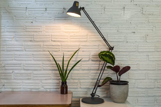 Modern lamp and pot on the desk on white wall background.