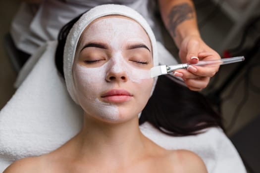 Close-up shot of a woman getting facial treatment with clay mask. Cosmetology and spa. High quality 4k footage