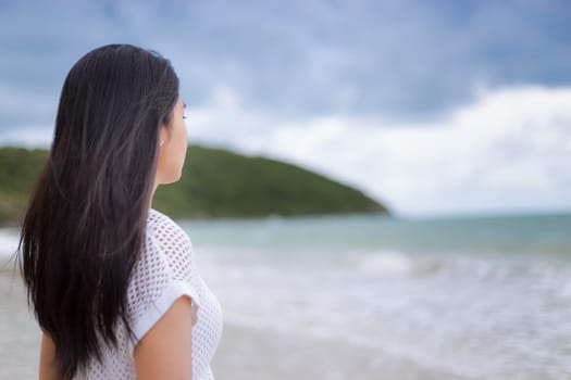 A portrait of a beautiful asian woman in the white shirt standing on the balcony