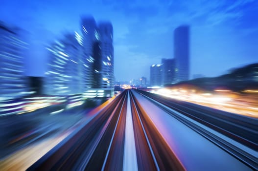 High speed train passing in between Kuala Lumpur City during dusk hour. Focus on the rail road.