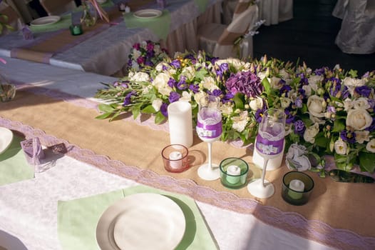 Beautifully decorated table for the wedding ceremony. Served banquet table decorated with fresh flowers in the open air.