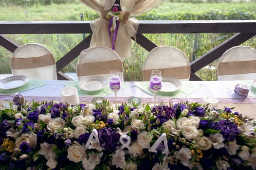 Beautifully decorated table for the wedding ceremony. Served banquet table decorated with fresh flowers in the open air.