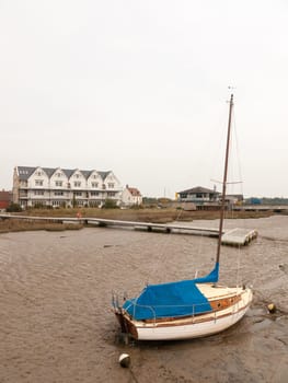 parked private boat with mast on mud sea front dock  essex  england  uk