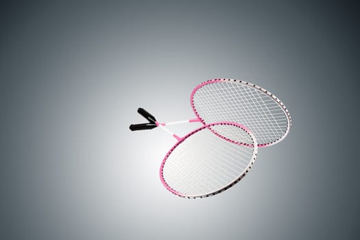 Color photo of two rackets for badminton isolated on gray