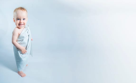 a one-year-old girl in a toga looking up on white background. Banner with copy space