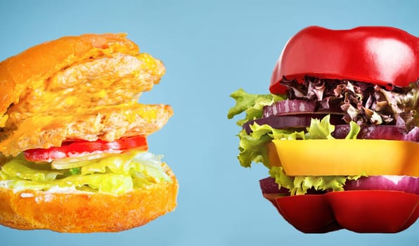 Healthy sandwich with fresh pepper, onion, salad lettuce and unhealthy harmful hamburger. Concept of diet.