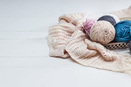 The balls of wool and needles on blue studio background