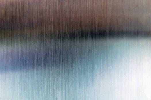 Convex polished shiny steel metal surface with colored reflections and glare.