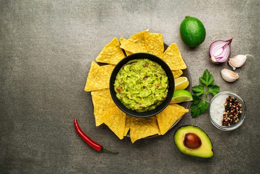Guacamole sauce with fresh ingredients and corn nachos chips