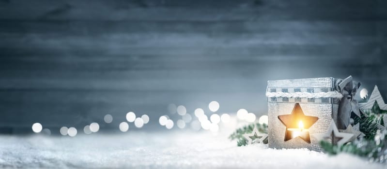 Christmas background in cool winter colors with a shining lantern,wood board,fir branches,ornaments and out of focus lights