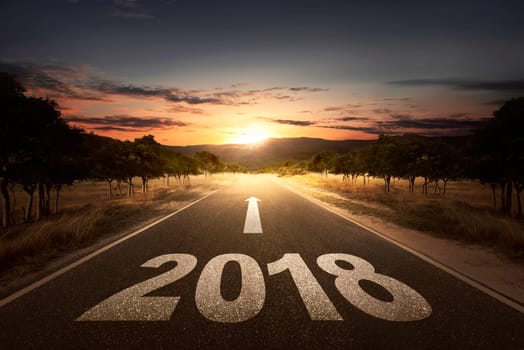 Empty street with arrow and 2018 number over sunset background
