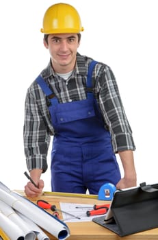 a worker measuring a board with a tape measure