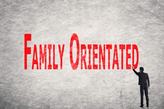 Asian business man write words on wall, Family Orientated